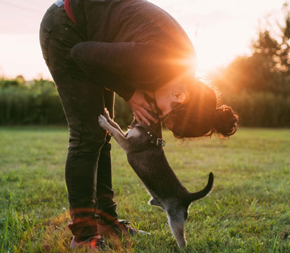 Persona dando una beso a un cachorro